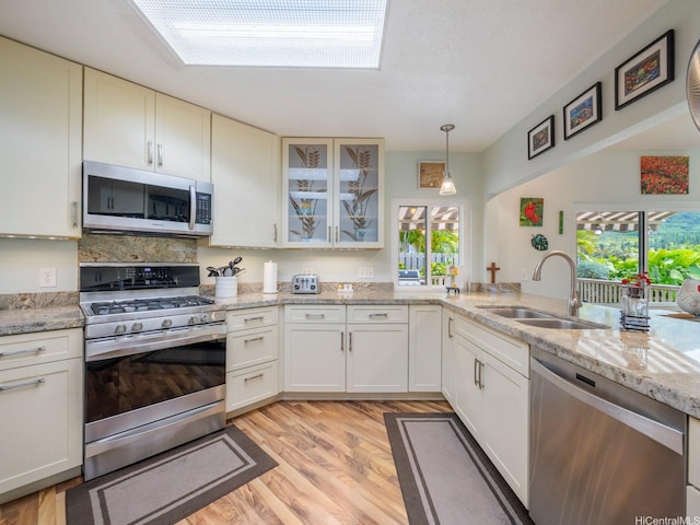 1586 Paukiki St, Kailua, HI 96734 - kitchen with appliances with stainless steel finishes, healthy amount of natural light, glass insert cabinets, and light wood-style flooring