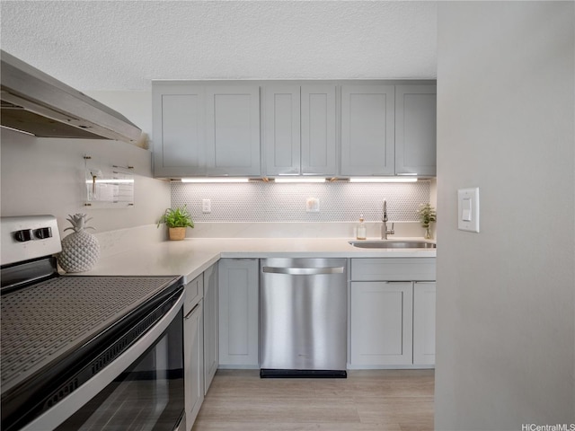 1060 Kamehameha Hwy Unit 2103A, Pearl City, HI 96782 - kitchen featuring appliances with stainless steel finishes, gray cabinetry, light wood-type flooring, backsplash, and light countertops