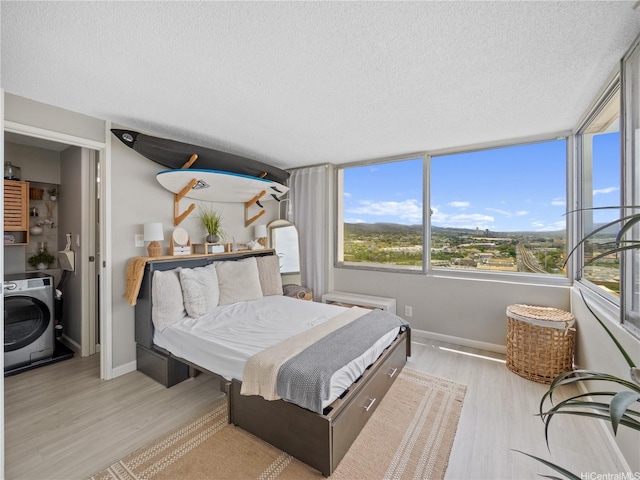 1060 Kamehameha Hwy Unit 2103A, Pearl City, HI 96782 - bedroom featuring washer / clothes dryer, light wood-style floors, and a textured ceiling