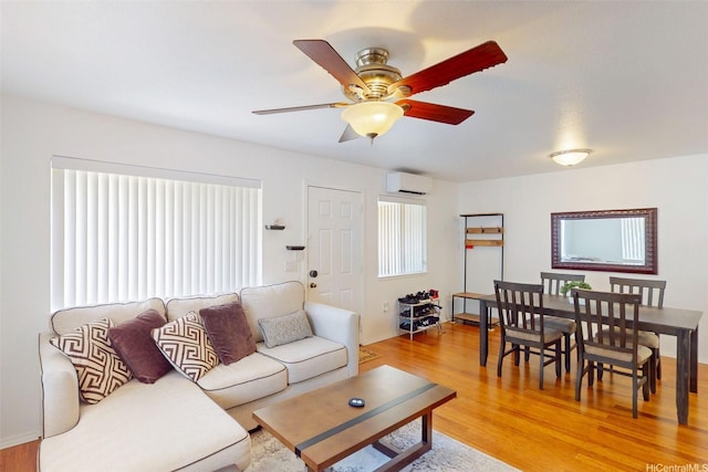 91-1105 Namahoe St Unit 2G, Kapolei, HI 96707 - living room featuring a wall mounted air conditioner, ceiling fan, and light wood-style flooring