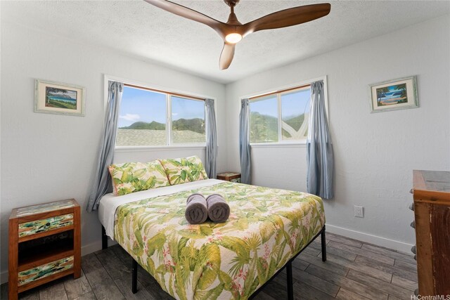 54-257 Kaipapau Loop, Hauula, HI 96717 - bedroom featuring multiple windows, wood finished floors, ceiling fan, and a textured ceiling