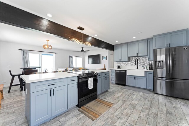 54-257 Kaipapau Loop, Hauula, HI 96717 - kitchen with appliances with stainless steel finishes, light countertops, light wood-type flooring, backsplash, and decorative light fixtures