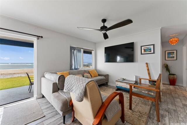 54-257 Kaipapau Loop, Hauula, HI 96717 - living area with wood finished floors, a ceiling fan, and view of water and beach