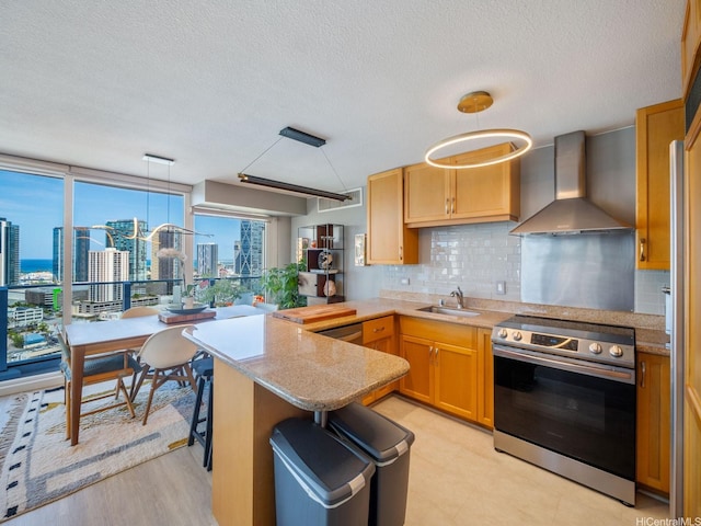 1288 Kapiolani Blvd Unit I2808, Honolulu, HI 96814 - kitchen featuring wall chimney exhaust hood, stainless steel range with electric cooktop, a city view, decorative backsplash, and light countertops