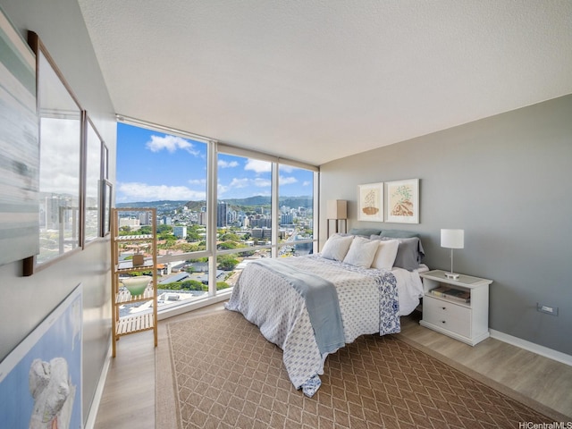 1288 Kapiolani Blvd Unit I2808, Honolulu, HI 96814 - bedroom with wood finished floors, multiple windows, a wall of windows, and a city view