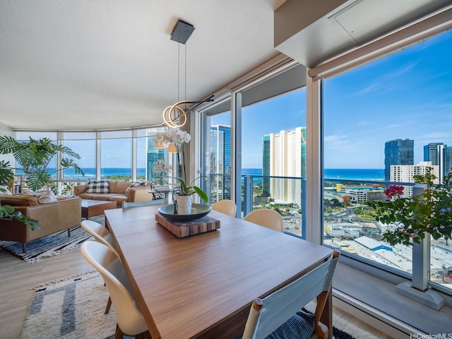 1288 Kapiolani Blvd Unit I2808, Honolulu, HI 96814 - dining area featuring a view of city, wood finished floors, a chandelier, a water view, and a textured ceiling