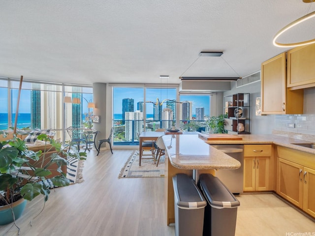 1288 Kapiolani Blvd Unit I2808, Honolulu, HI 96814 - kitchen with stainless steel dishwasher, light brown cabinetry, floor to ceiling windows, light wood finished floors, and a city view