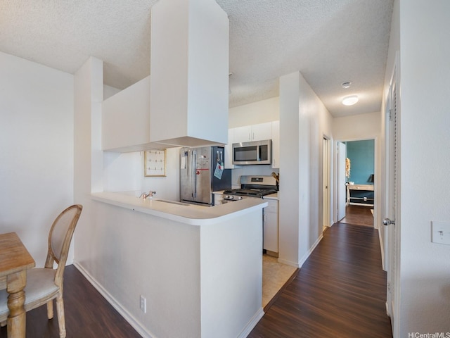 91-265 Hanapouli Cir Unit 16J, Ewa Beach, HI 96706 - kitchen with appliances with stainless steel finishes, wood finished floors, white cabinets, a textured ceiling, and light countertops