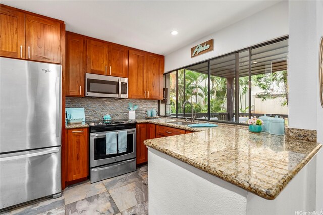 46-160 Kiowai St Unit 2322, Kaneohe, HI 96744 - kitchen with appliances with stainless steel finishes, light stone countertops, backsplash, brown cabinetry, and recessed lighting