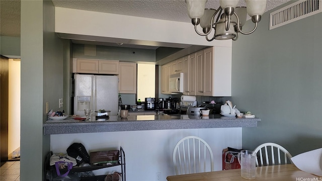 990 Ala Nanala St Unit 22B, Honolulu, HI 96818 - kitchen with white appliances, a chandelier, cream cabinets, dark countertops, and a textured ceiling