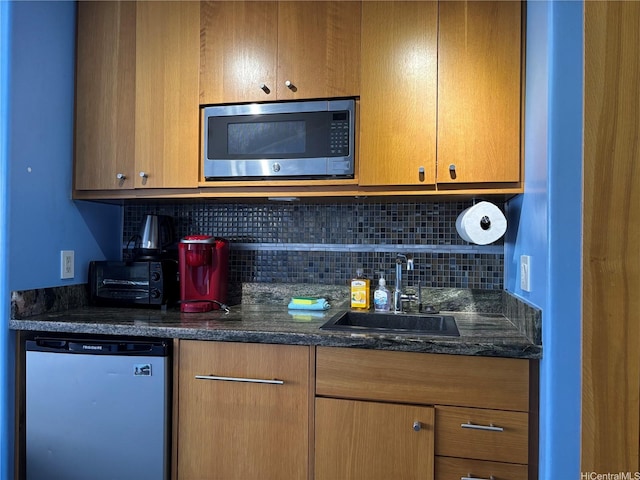 1700 Ala Moana Blvd Unit 2001, Honolulu, HI 96815 - kitchen featuring stainless steel microwave, dishwashing machine, backsplash, and dark stone countertops