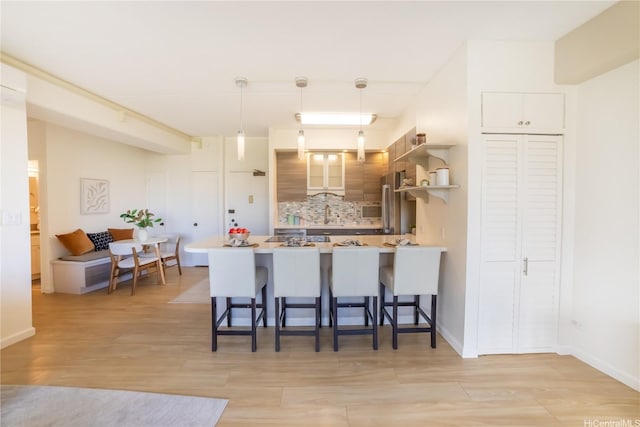 2333 Kapiolani Blvd Unit 311, Honolulu, HI 96826 - kitchen with a peninsula, a breakfast bar area, open shelves, and light wood finished floors