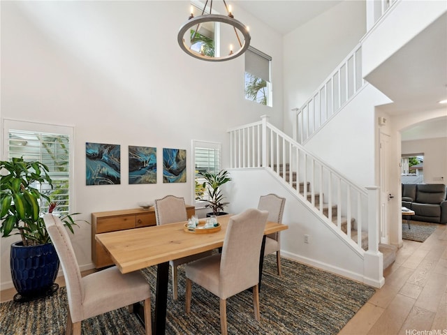 91-1032 Kaikane St, Ewa Beach, HI 96706 - dining area featuring healthy amount of natural light, wood-type flooring, a chandelier, and a towering ceiling