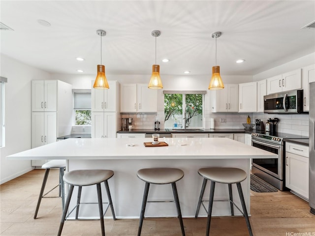 91-1032 Kaikane St, Ewa Beach, HI 96706 - kitchen featuring appliances with stainless steel finishes, tasteful backsplash, a kitchen island, a kitchen breakfast bar, and recessed lighting