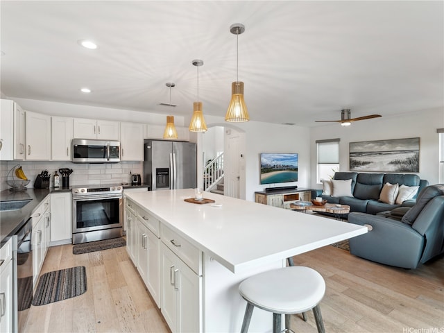 91-1032 Kaikane St, Ewa Beach, HI 96706 - kitchen with stainless steel appliances, light wood-style floors, a center island, decorative backsplash, and open floor plan
