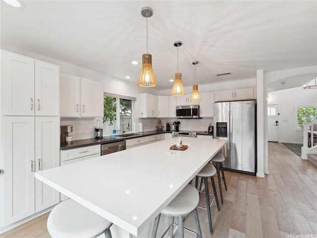 91-1032 Kaikane St, Ewa Beach, HI 96706 - kitchen featuring appliances with stainless steel finishes, healthy amount of natural light, a breakfast bar, decorative backsplash, and recessed lighting