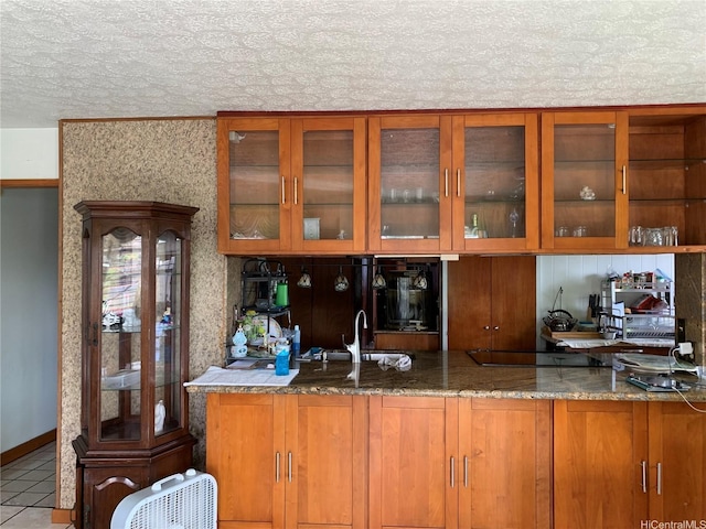 1617 Kamehameha Iv Rd, Honolulu, HI 96819 - kitchen featuring black electric stovetop, brown cabinetry, glass insert cabinets, tile patterned floors, and stone countertops