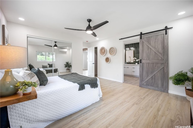 1849 Vancouver Pl, Honolulu, HI 96822 - bedroom with a barn door, light wood-style floors, a wall mounted AC, a ceiling fan, and recessed lighting