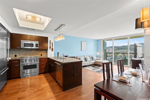 1837 Kalakaua Ave Unit 2209, Honolulu, HI 96815 - kitchen featuring high quality appliances, open floor plan, tasteful backsplash, light wood-style floors, and a peninsula