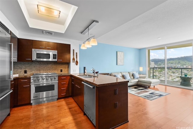 1837 Kalakaua Ave Unit 2209, Honolulu, HI 96815 - kitchen featuring high end appliances, open floor plan, decorative backsplash, a peninsula, and light wood-style floors