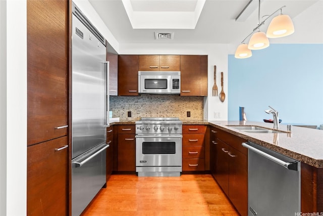 1837 Kalakaua Ave Unit 2209, Honolulu, HI 96815 - kitchen with high quality appliances, a peninsula, light wood-style floors, tasteful backsplash, and stone countertops