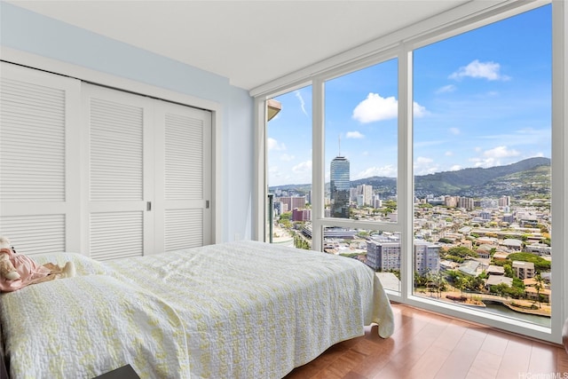 1837 Kalakaua Ave Unit 2209, Honolulu, HI 96815 - bedroom with floor to ceiling windows, wood finished floors, a city view, a closet, and a mountain view