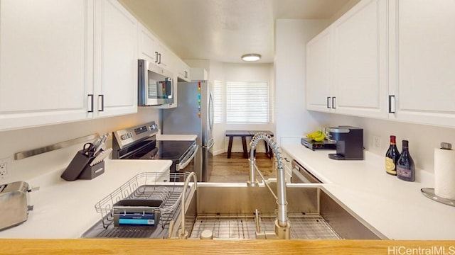 92-1226 Palahia St Unit Cc105, Kapolei, HI 96707 - kitchen featuring stainless steel appliances, light countertops, white cabinets, and wood finished floors