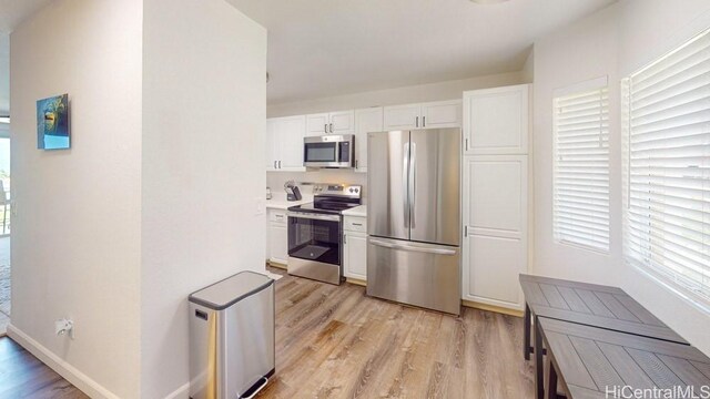 92-1226 Palahia St Unit Cc105, Kapolei, HI 96707 - kitchen with stainless steel appliances, light wood finished floors, white cabinets, and light countertops