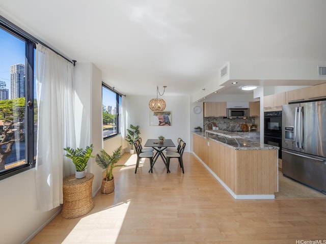 2232 Kapiolani Blvd Unit 303, Honolulu, HI 96826 - kitchen with appliances with stainless steel finishes, light brown cabinets, a peninsula, backsplash, and light wood finished floors
