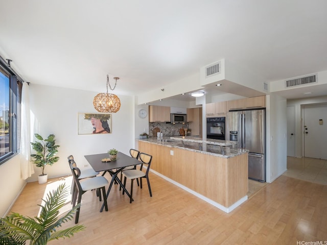2232 Kapiolani Blvd Unit 303, Honolulu, HI 96826 - kitchen with appliances with stainless steel finishes, light brown cabinetry, a peninsula, light wood finished floors, and decorative backsplash