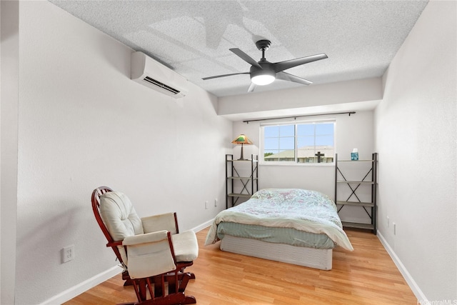 91-1024 Kaiau Ave Unit 4E, Kapolei, HI 96707 - bedroom featuring a wall mounted air conditioner, wood finished floors, a textured ceiling, and ceiling fan