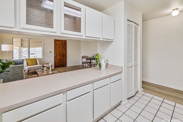 98-219 Pahemo St, Aiea, HI 96701 - kitchen featuring light countertops, white cabinets, glass insert cabinets, and light tile patterned flooring