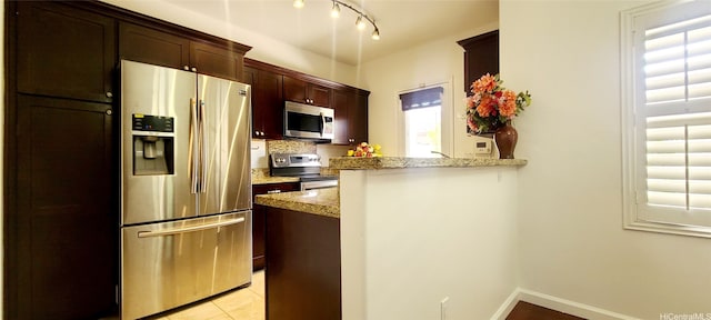 91-6560 Kapolei Pkwy Unit 3G5, Ewa Beach, HI 96706 - kitchen with stainless steel appliances, light stone counters, healthy amount of natural light, and a peninsula