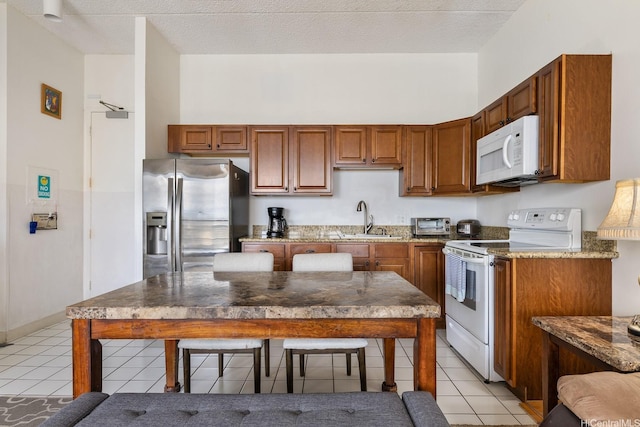 201 Ohua Ave Unit 3702-1, Penthouse Honolulu, HI 96815 - kitchen with white appliances, light tile patterned flooring, and brown cabinetry