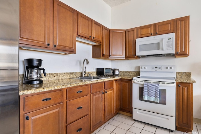 201 Ohua Ave Unit 3702-1, Penthouse Honolulu, HI 96815 - kitchen with white appliances, brown cabinetry, light tile patterned flooring, and light stone counters