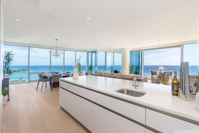 1118 Ala Moana Blvd Unit 2000/2002, Honolulu, HI 96814 - kitchen featuring a wall of windows, white cabinetry, light countertops, light wood-style floors, and open floor plan
