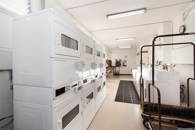 445 Kaiolu St Unit 407, Honolulu, HI 96815 - kitchen with stacked washer / drying machine, white cabinetry, washing machine and dryer, and light floors