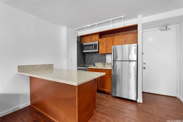 445 Kaiolu St Unit 407, Honolulu, HI 96815 - kitchen featuring stainless steel appliances, brown cabinetry, track lighting, decorative backsplash, and dark wood-style flooring