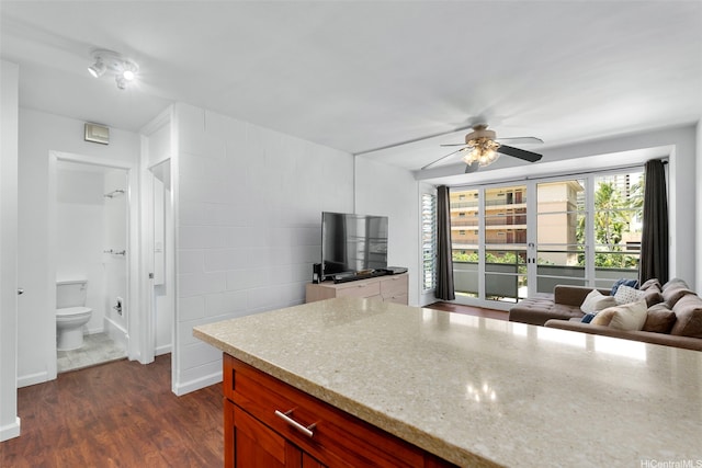 445 Kaiolu St Unit 407, Honolulu, HI 96815 - kitchen with light stone counters, a ceiling fan, dark wood-style floors, and open floor plan