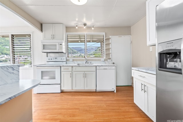 2061 10th Ave, Honolulu, HI 96816 - kitchen featuring white appliances, healthy amount of natural light, light wood-type flooring, and white cabinets