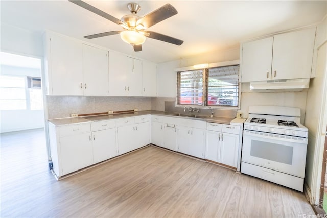 741 Alewa Dr Unit A, Honolulu, HI 96817 - kitchen with white range with gas cooktop, under cabinet range hood, light wood-style flooring, white cabinetry, and tasteful backsplash