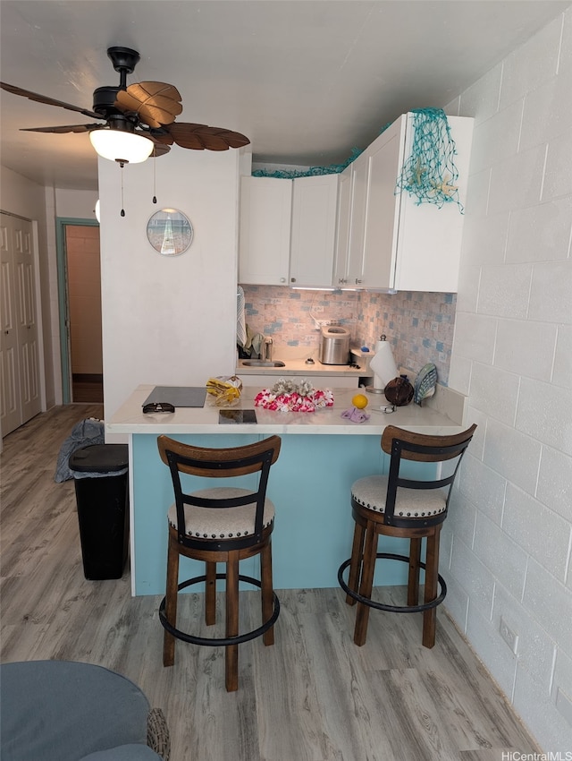 53-549 Kamehameha Hwy Unit 211, Hauula, HI 96717 - kitchen featuring ceiling fan, light countertops, white cabinetry, and light wood-style flooring