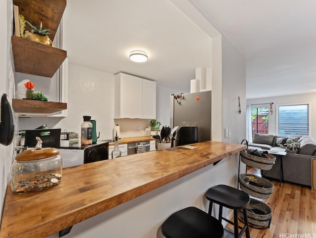 46-63 Emepela Pl Unit P205, Kaneohe, HI 96744 - kitchen with butcher block countertops, open shelves, light wood finished floors, appliances with stainless steel finishes, and white cabinets