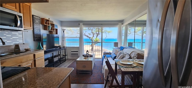 85-175 Farrington Hwy Unit A315, Waianae, HI 96792 - kitchen with stainless steel microwave, dark wood finished floors, brown cabinetry, and dark stone countertops