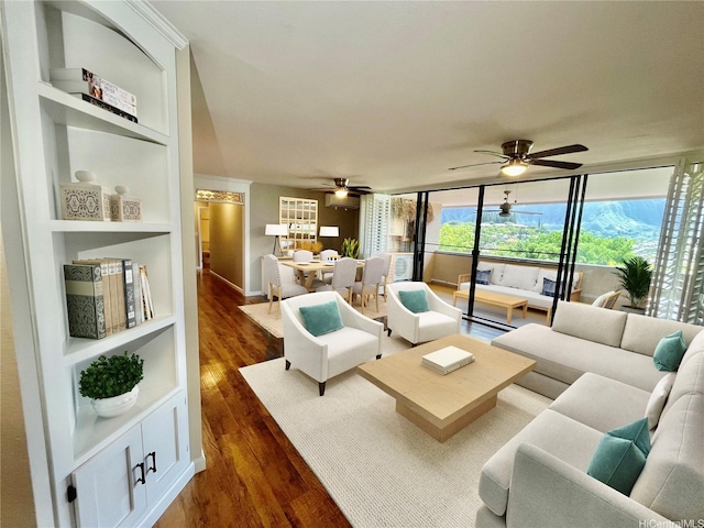 46-035 Konohiki St Unit 3832, Kaneohe, HI 96744 - living area featuring ceiling fan, dark wood finished floors, a wall of windows, and built in shelves