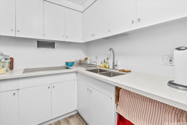1350 Ala Moana Blvd Unit 3004, Honolulu, HI 96814 - kitchen featuring electric stovetop, light countertops, white cabinetry, and light wood-style floors