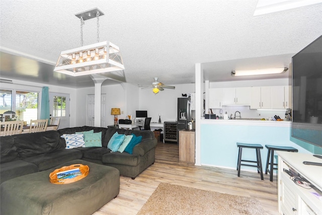 94-271 Kupulau Pl, Mililani, HI 96789 - living area featuring a textured ceiling, light wood-style floors, a ceiling fan, and beverage cooler