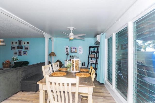 94-271 Kupulau Pl, Mililani, HI 96789 - dining space featuring a wall mounted air conditioner, a ceiling fan, light wood-style floors, and arched walkways