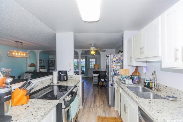 94-271 Kupulau Pl, Mililani, HI 96789 - kitchen with appliances with stainless steel finishes, white cabinetry, light wood-style flooring, ceiling fan, and a textured ceiling