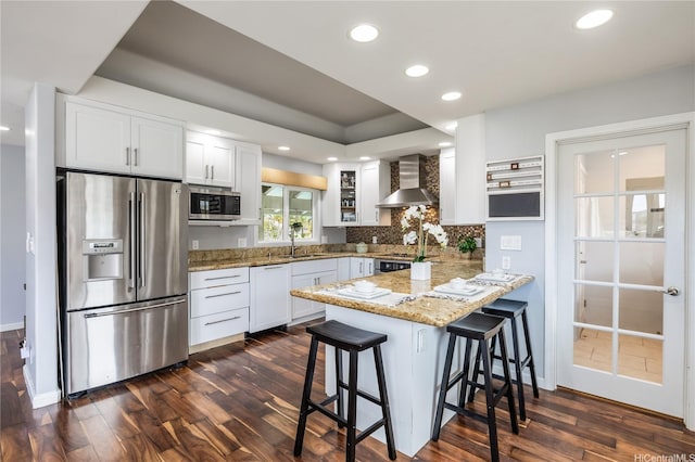 1048 Kaupaku Pl, Honolulu, HI 96825 - kitchen featuring stainless steel appliances, wall chimney range hood, dark wood-type flooring, a peninsula, and recessed lighting